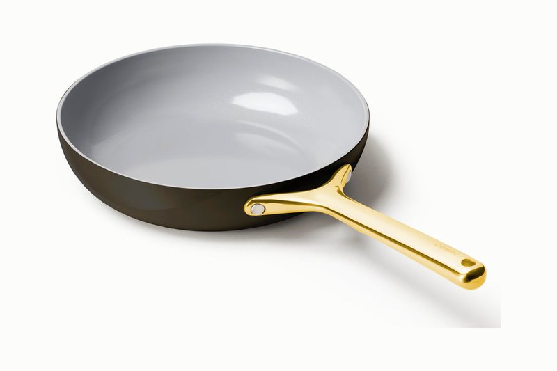 Caraway ceramic-coated fry pan with a cream non-stick interior, dark exterior and gold handle