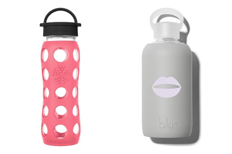 A Lifefactory glass bottle in a coral silicone sleeve next to a bkr glass bottle in a grey sleeve