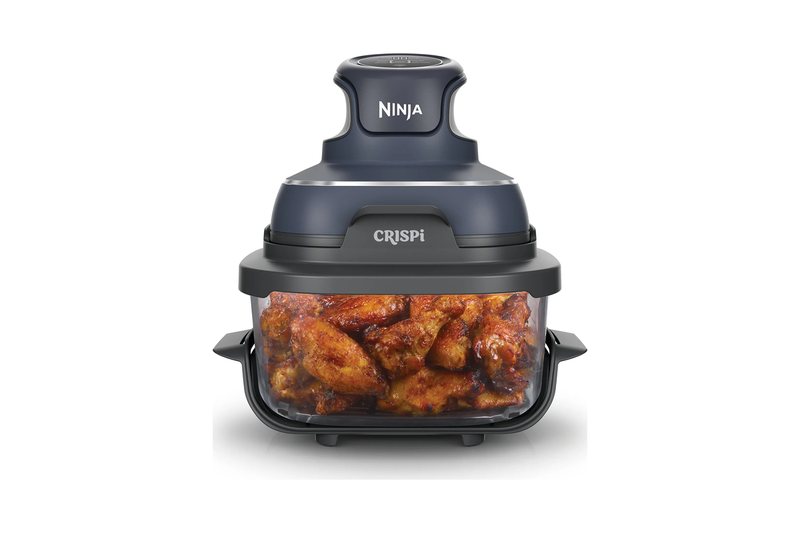 Ninja Crispi portable glass air fryer: a glass container of chicken wings with the grey Ninja Crispi lid unit on top
